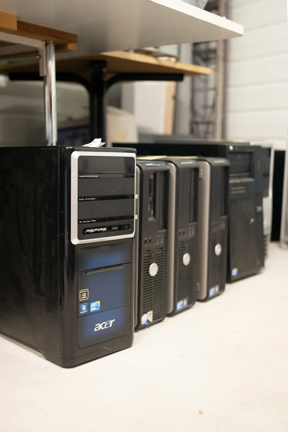 A row of retired business desktop tower PCs cleared from an office