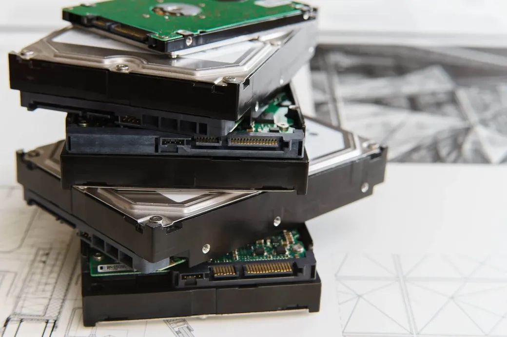 A stack of computer hard drives and storage media